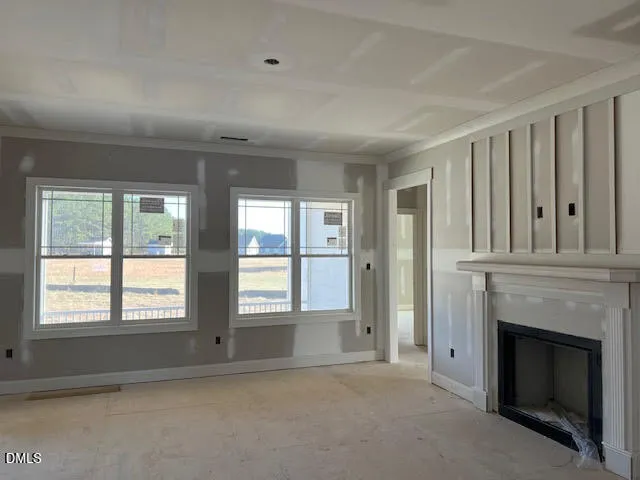 a view of an empty room with a fireplace and a window