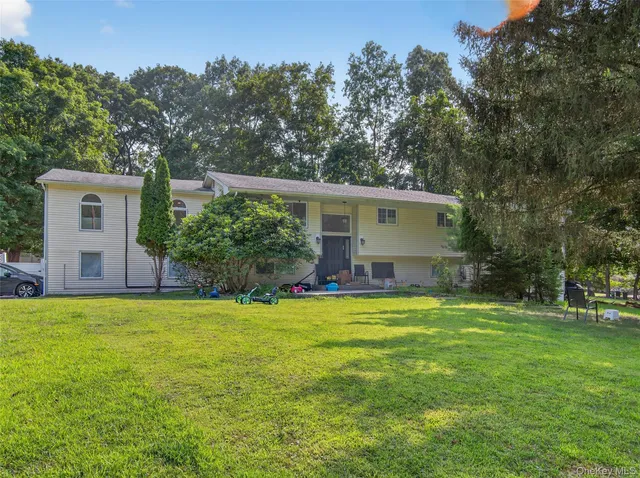 a view of a house with a yard and a tree