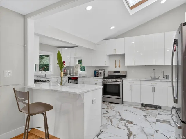 a kitchen with a stove a sink a microwave a dining table and chairs