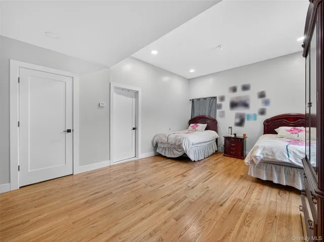 a bedroom with two beds and a wooden floor