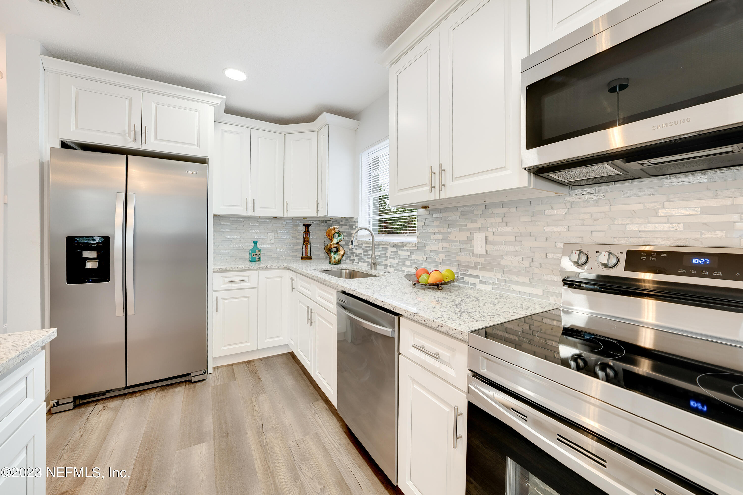7404 Bamberg Road Jacksonville, FL 32277 - Photo 12 of 31 a kitchen with stainless steel appliances a refrigerator stove and sink