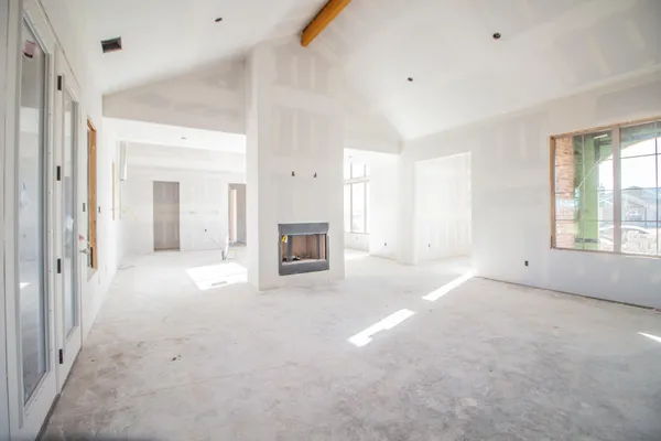 an empty room with windows and fireplace