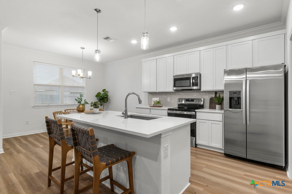 8114 Timber Hollow Lane Temple, TX 76502 - Photo 12 of 34 a kitchen with kitchen island a counter space a sink appliances and cabinets