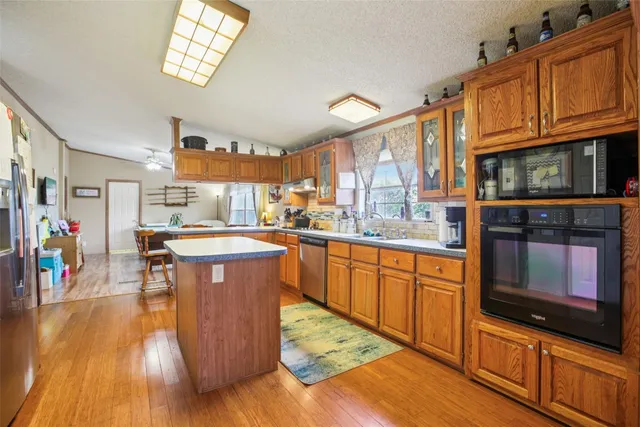 a kitchen with stainless steel appliances granite countertop a stove a sink and a wooden cabinets