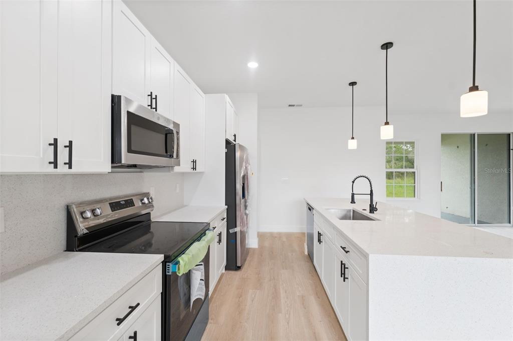 3261 Southwest 129th Loop Ocala, FL 34473 - Photo 12 of 32 a kitchen with a sink stove and refrigerator
