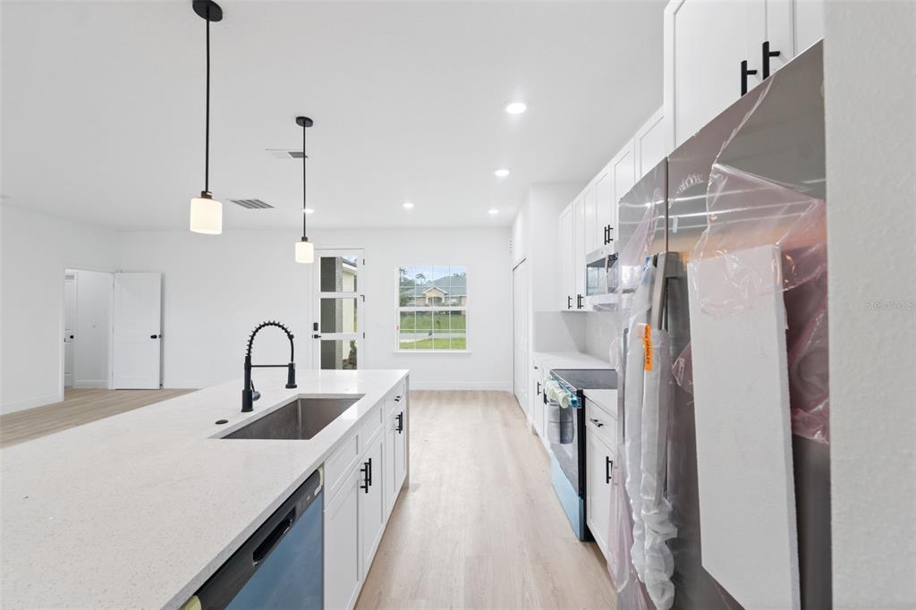 3261 Southwest 129th Loop Ocala, FL 34473 - Photo 14 of 32 a kitchen with a refrigerator a sink and cabinets