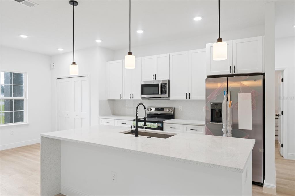 3261 Southwest 129th Loop Ocala, FL 34473 - Photo 15 of 32 a kitchen with stainless steel appliances a refrigerator sink and microwave