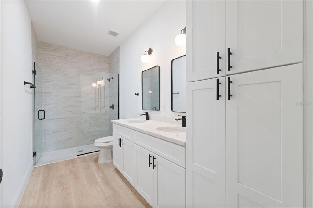 3261 Southwest 129th Loop Ocala, FL 34473 - Photo 19 of 32 a bathroom with a double vanity sink toilet mirror and shower