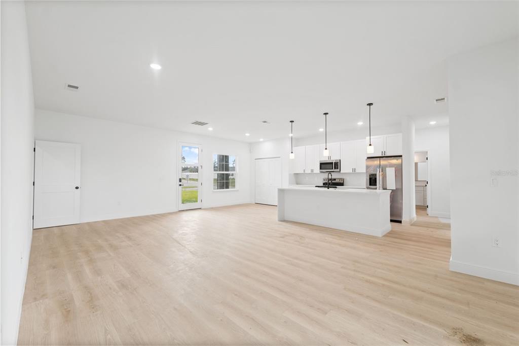 3261 Southwest 129th Loop Ocala, FL 34473 - Photo 7 of 32 a view of a kitchen with kitchen island a sink wooden floor and white cabinets