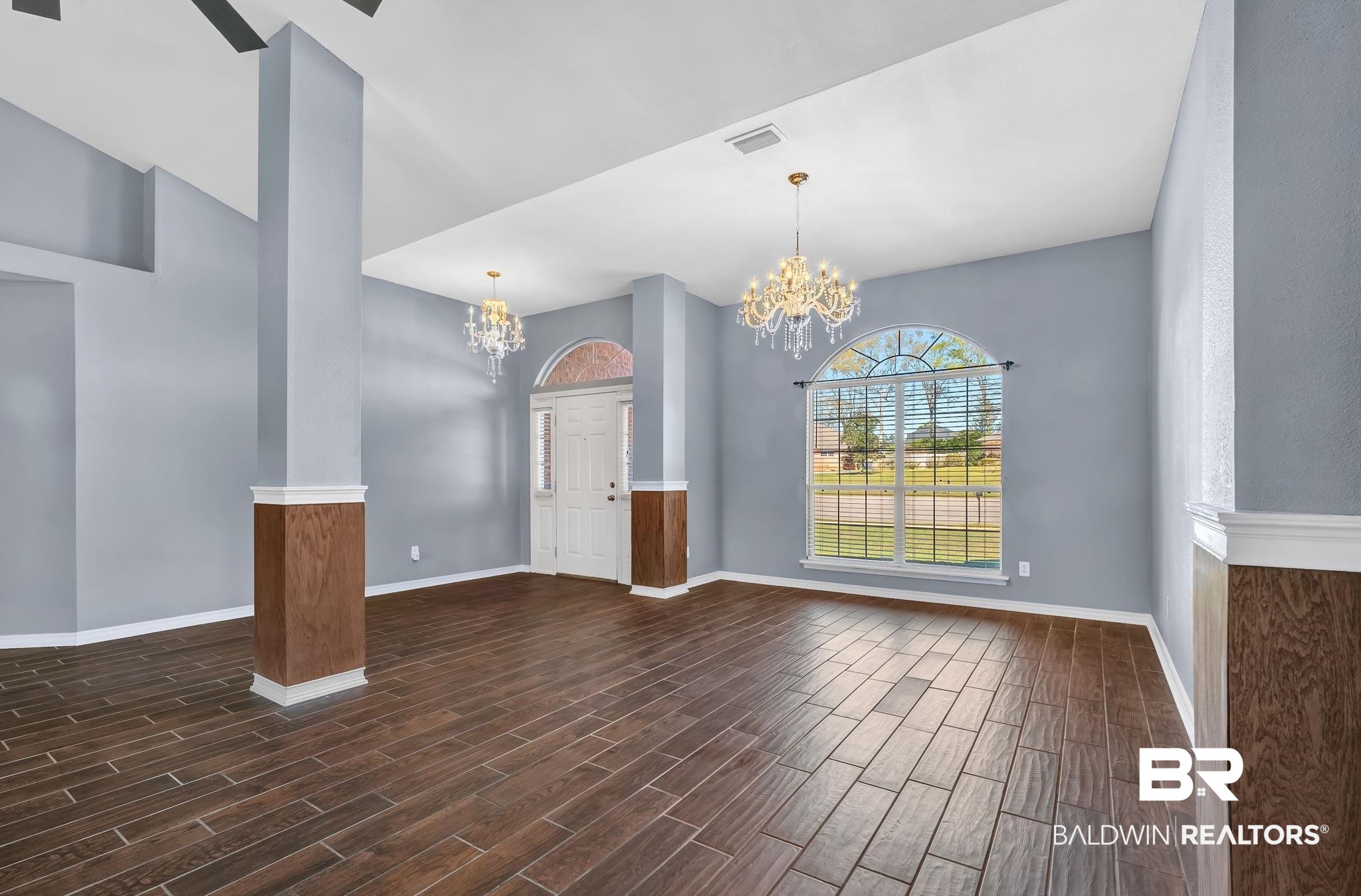 16444 Hamlet Lane Foley, AL 36535 - Photo 17 of 49 Empty room with baseboards, visible vents, wood finish floors, and an inviting chandelier