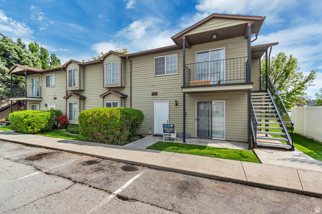 653 South 500 West, Unit 1 Provo, UT 84601 - Photo 2 of 17 Multi-level building exterior featuring light green siding, individual balconies with black railings, and bay window details