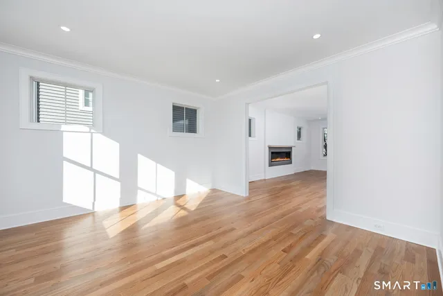 a view of a hallway with wooden floor a livingroom and chandelier