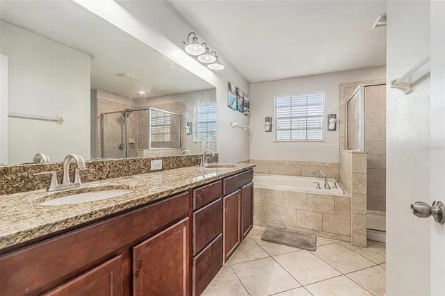 a bathroom with a granite countertop sink mirror and a bath tub