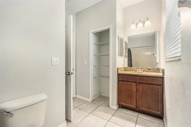 a bathroom with a granite countertop sink a toilet and a mirror