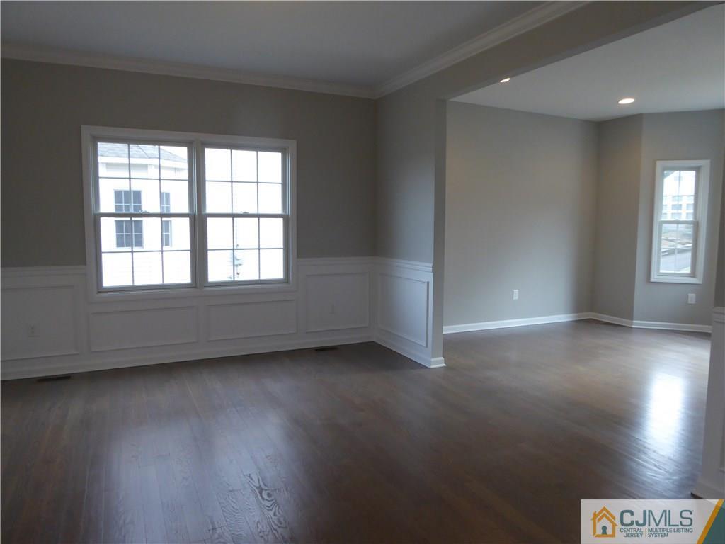 128 Normandy Road Colonia, NJ 07067 - Photo 8 of 41 an empty room with wooden floor and windows