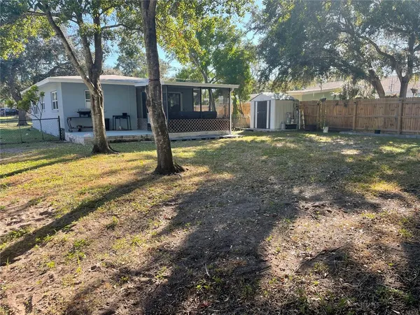 a view of a house with backyard and tree