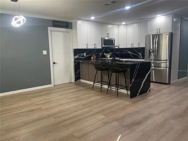 a kitchen with stainless steel appliances a refrigerator and a stove top oven