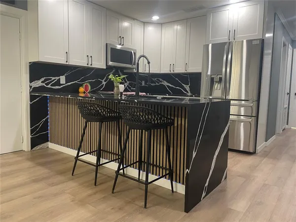 a view of a kitchen with refrigerator and workspace
