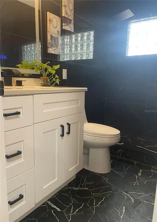 a bathroom with a sink toilet and window