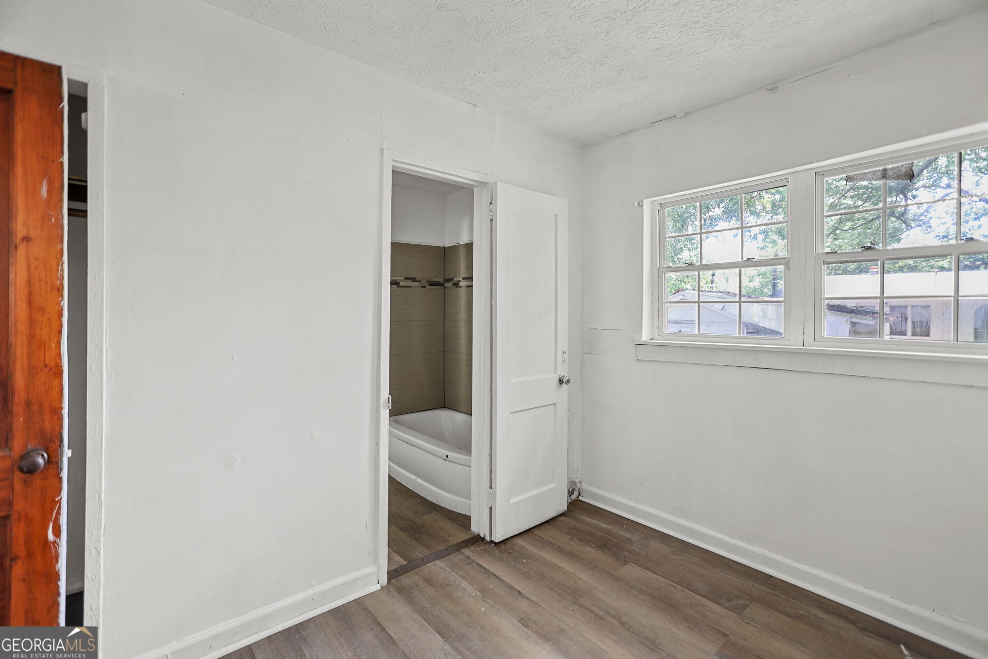 138 Main Street Sharpsburg, GA 30277 - Photo 15 of 34 an empty room with wooden floor and windows