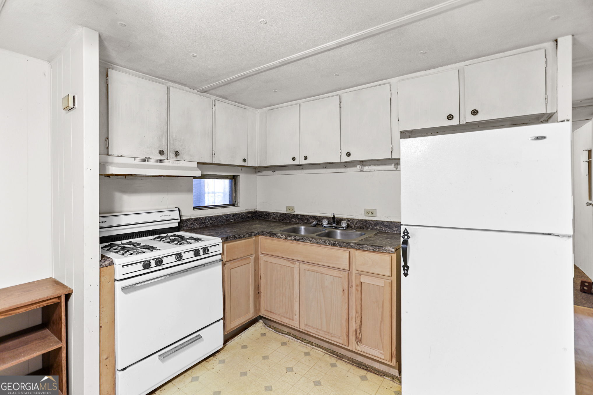 138 Main Street Sharpsburg, GA 30277 - Photo 20 of 34 a kitchen with granite countertop white refrigerator stove and white cabinets