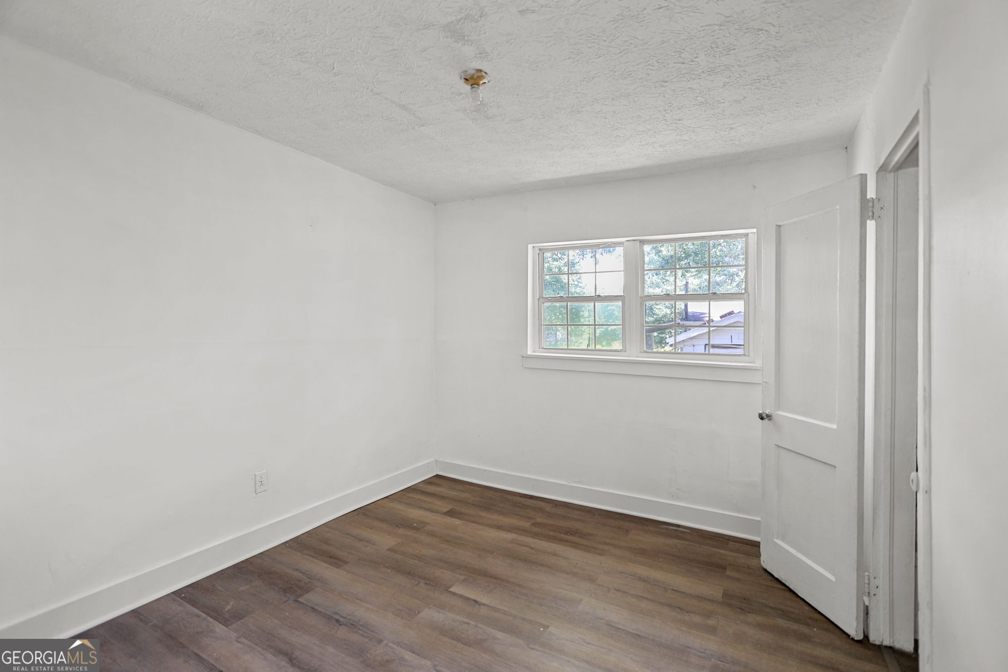 138 Main Street Sharpsburg, GA 30277 - Photo 10 of 34 an empty room with wooden floor and windows