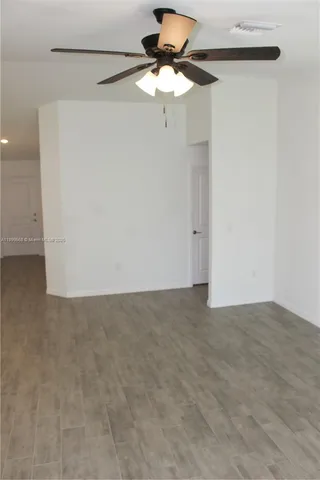 a living room with furniture a lamp and a ceiling fan