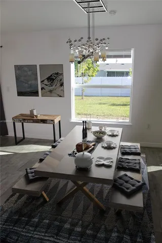a living room with stainless steel appliances kitchen island furniture and a chandelier