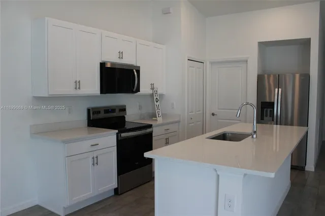 a kitchen with white cabinets and stainless steel appliances