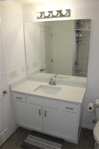 a white toilet sitting next to a wooden cabinet