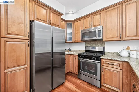 a kitchen with granite countertop cabinets stainless steel appliances and a window