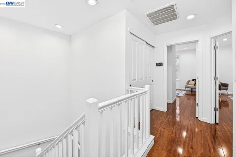 a view of a hallway with wooden floor and staircase