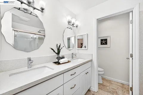 a bathroom with double vanity sinks and a mirror