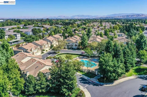 an aerial view of residential houses with outdoor space and trees