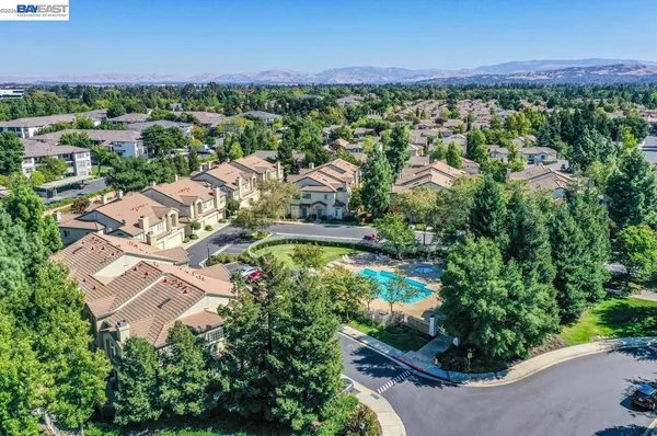 an aerial view of residential houses with outdoor space and trees