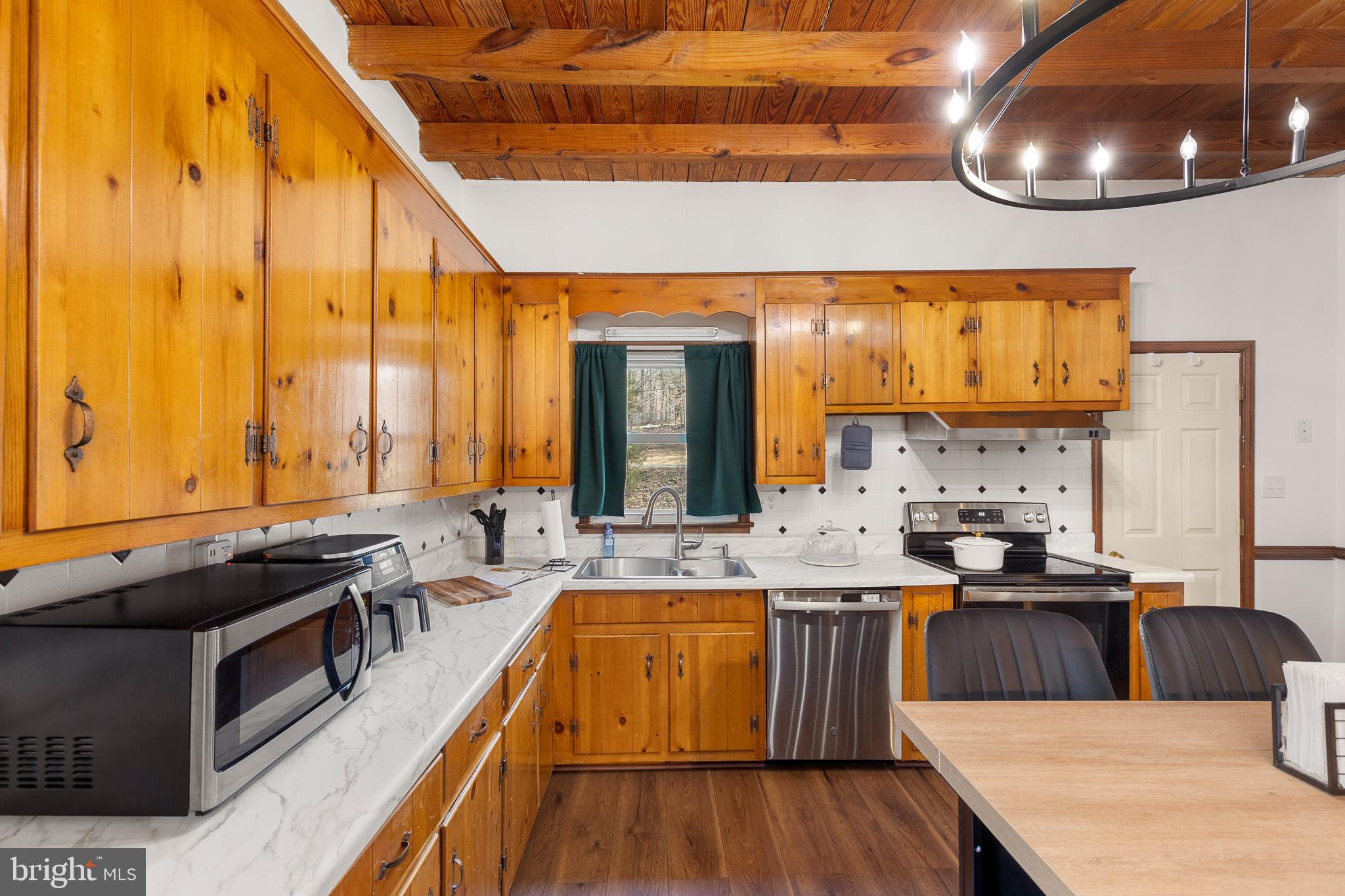 5708 Lakeview Road Quinton, VA 23141 - Photo 16 of 53 a large kitchen with stainless steel appliances a stove a sink dishwasher and cabinets with wooden floor