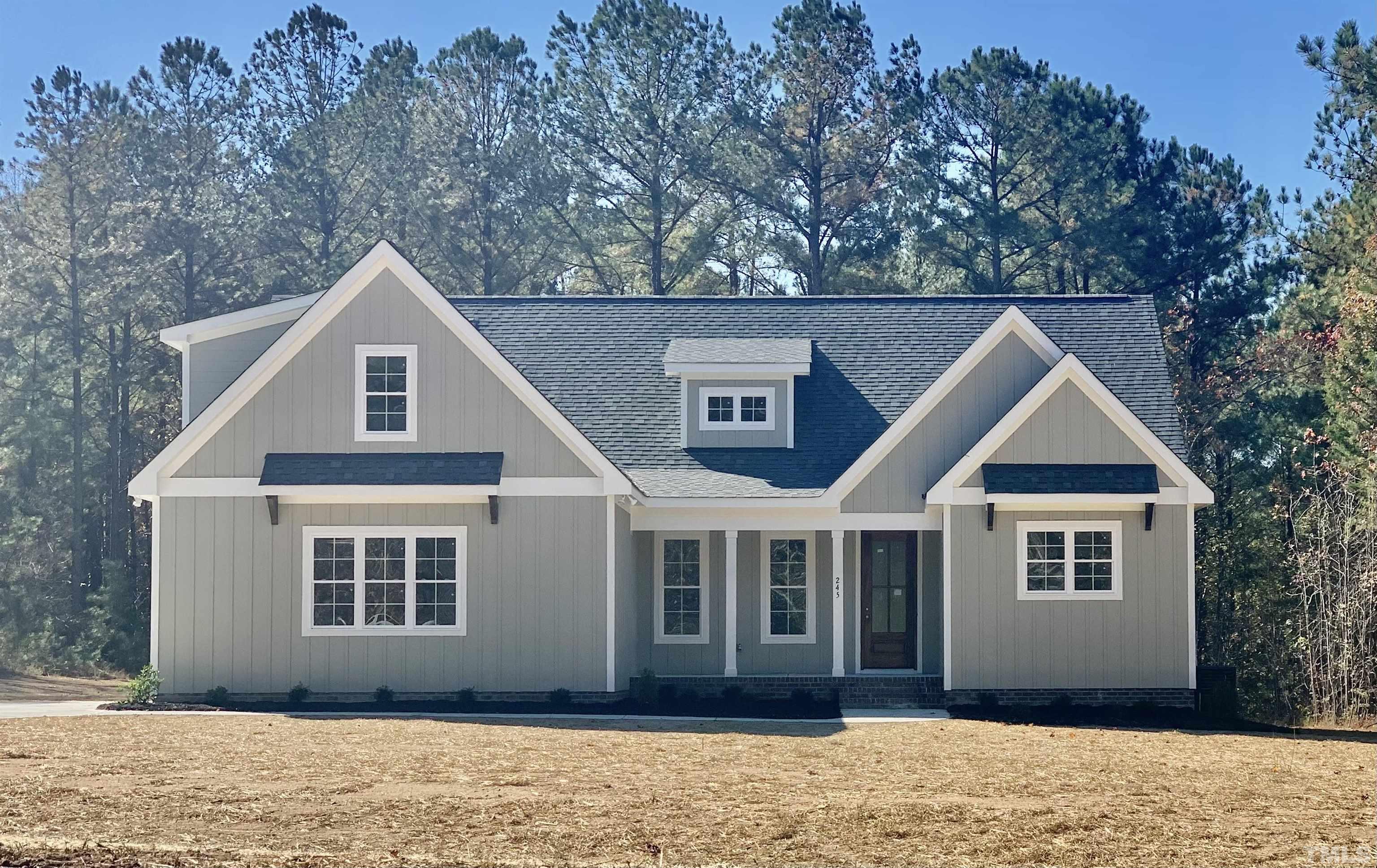 245 Whistlers Cove Louisburg, NC 27549 - Photo 1 of 27 a front view of a house with a yard and garage