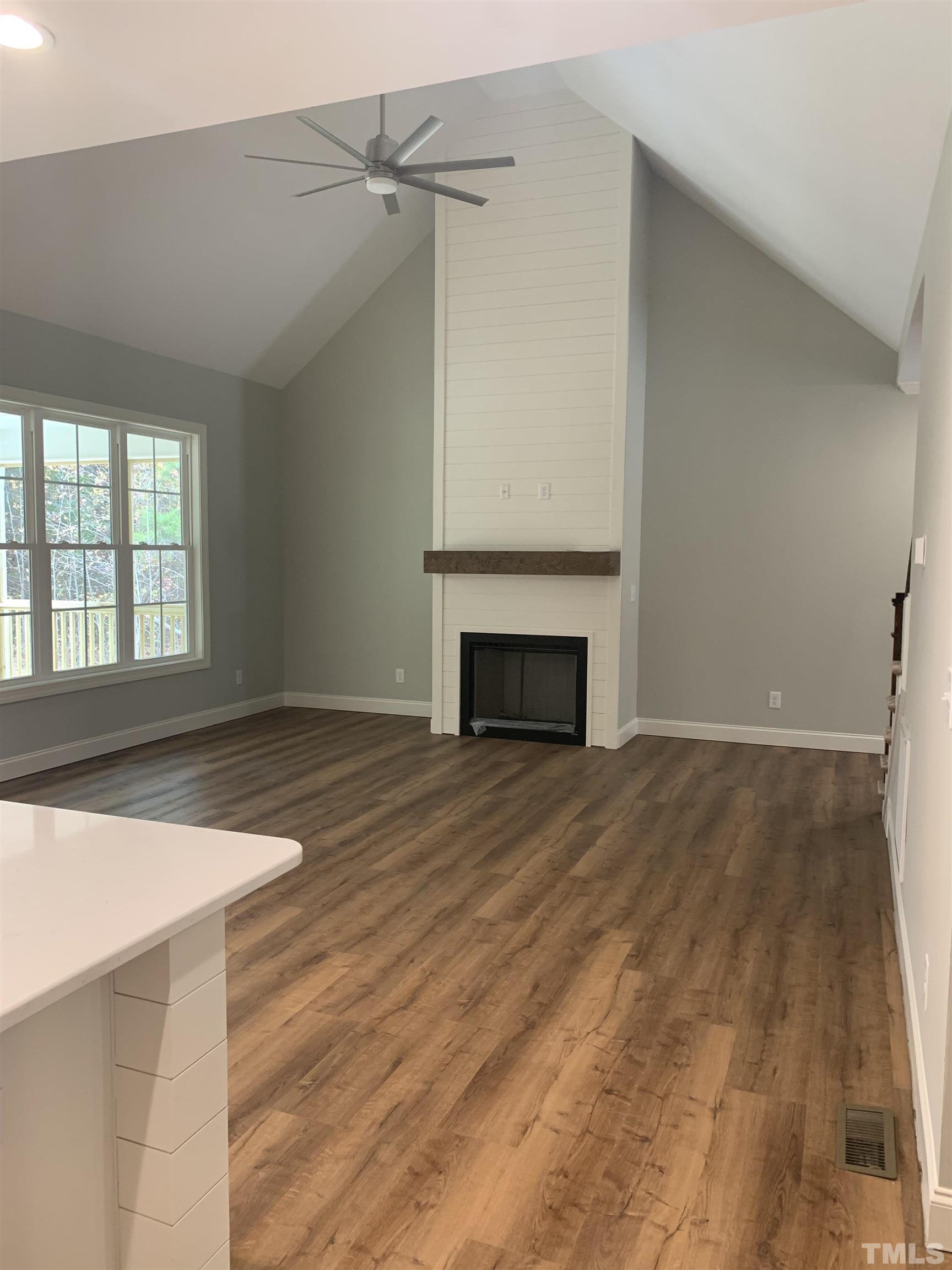 245 Whistlers Cove Louisburg, NC 27549 - Photo 13 of 27 a view of empty room with wooden floor and fireplace