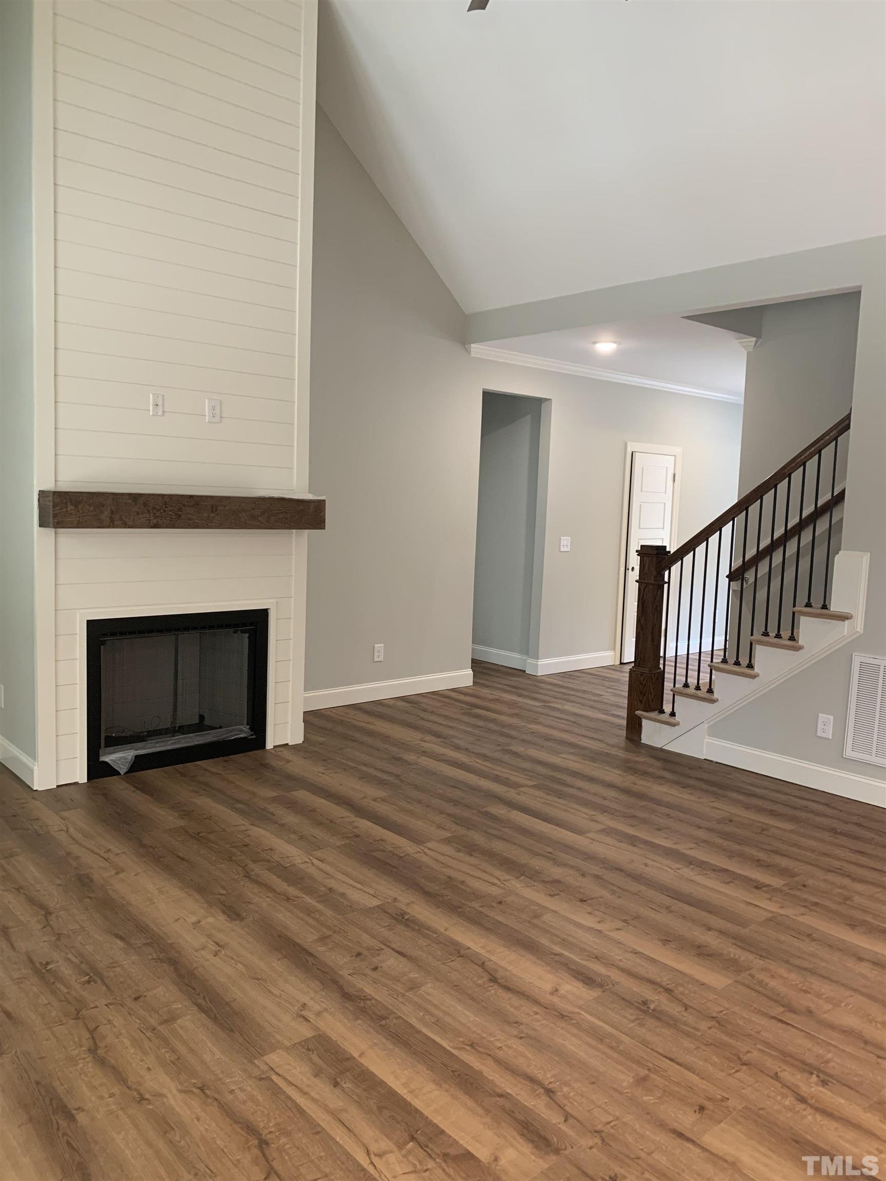 245 Whistlers Cove Louisburg, NC 27549 - Photo 16 of 27 a view of empty room with wooden floor and fireplace