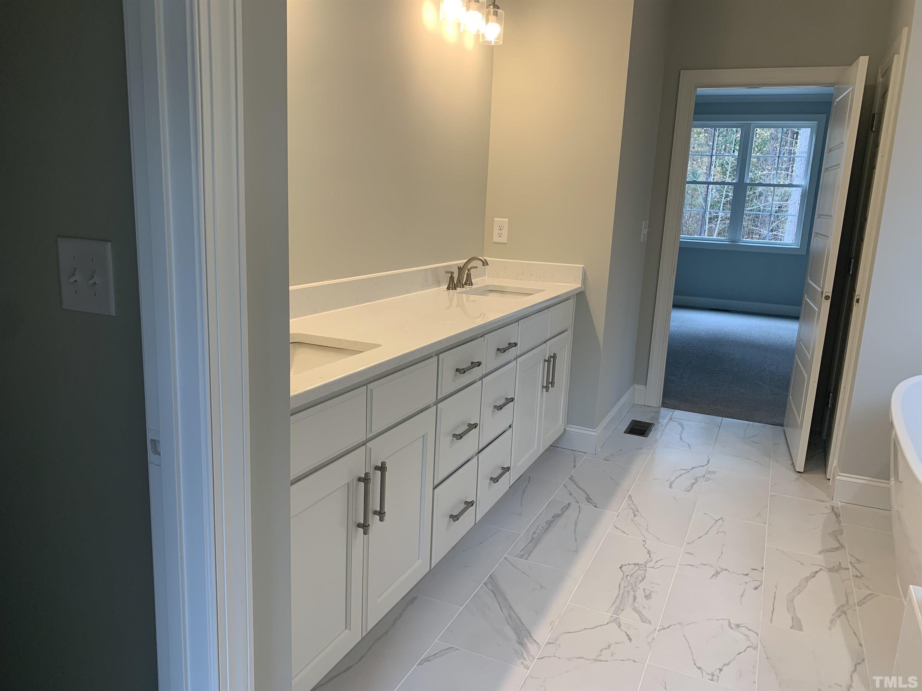 245 Whistlers Cove Louisburg, NC 27549 - Photo 20 of 27 a bathroom with a granite countertop sink a mirror and a vanity
