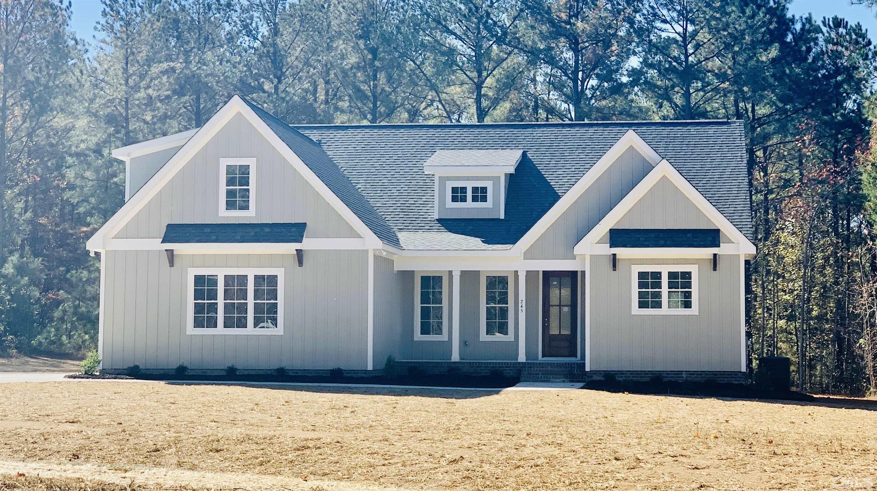 245 Whistlers Cove Louisburg, NC 27549 - Photo 2 of 27 a front view of a house with a yard covered in snow