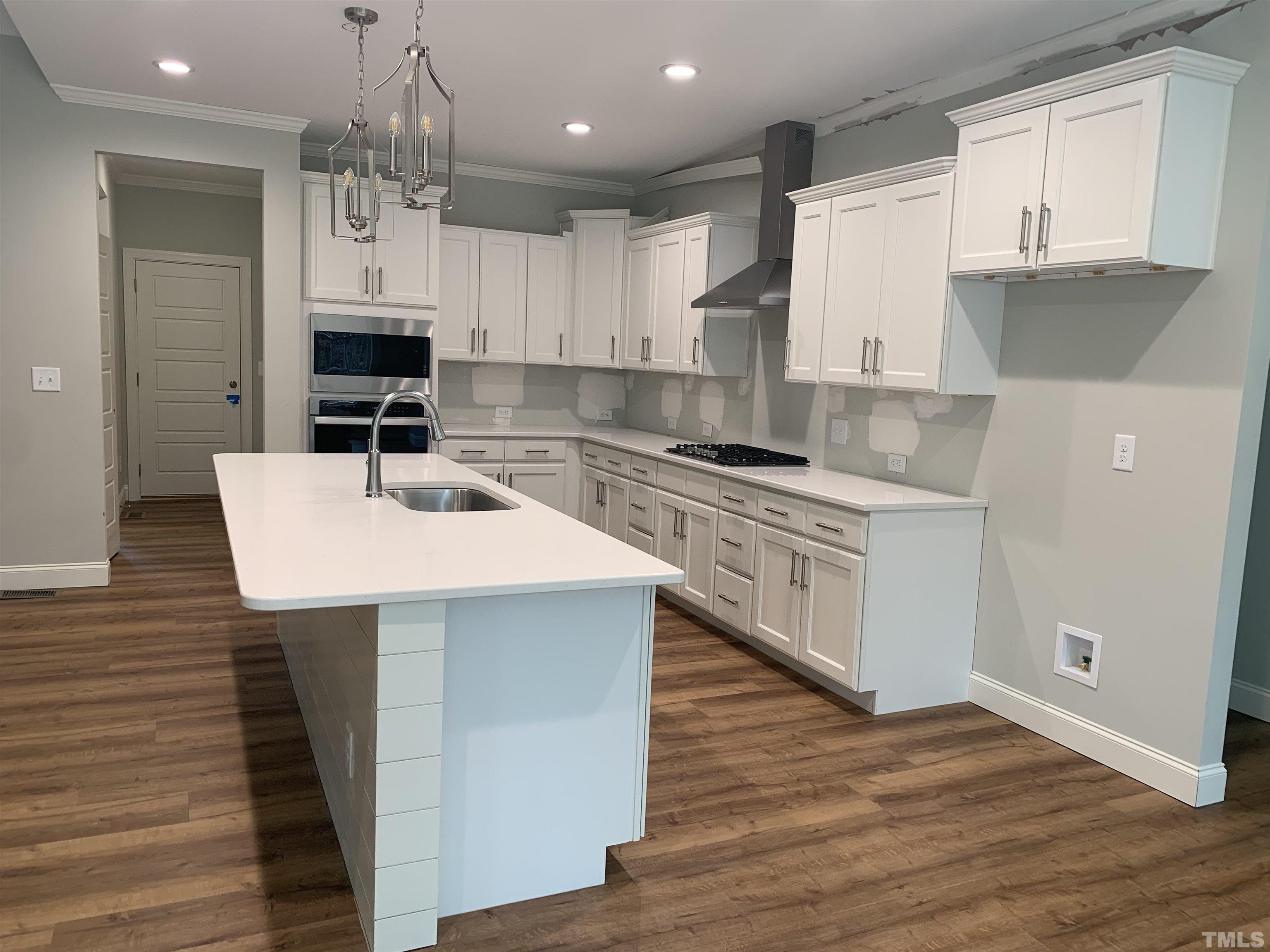245 Whistlers Cove Louisburg, NC 27549 - Photo 9 of 27 a kitchen with kitchen island a sink counter top space and cabinets