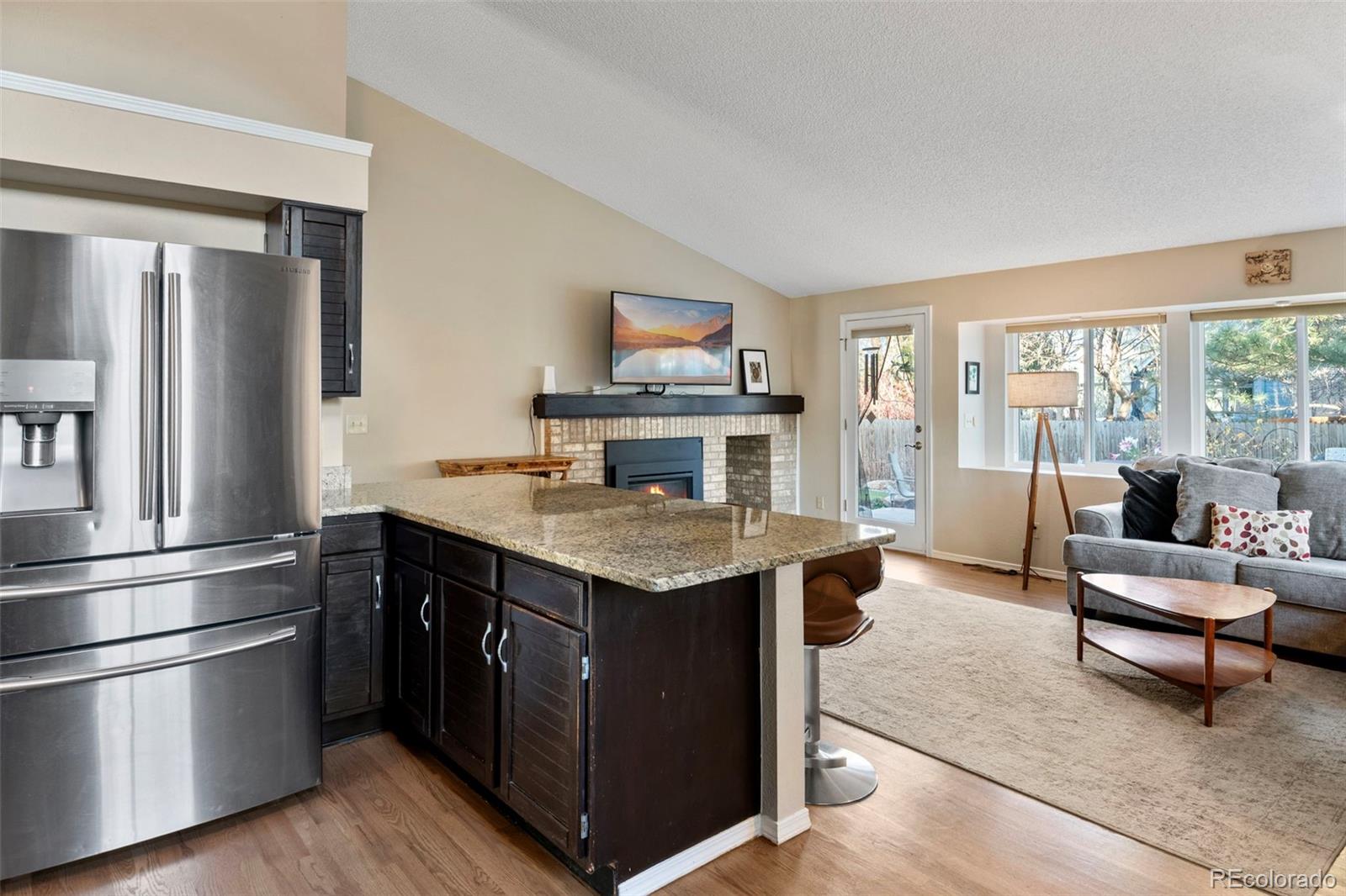 8482 Oak Street Arvada, CO 80005 - Photo 14 of 34 a kitchen with a stove a refrigerator and wooden floor