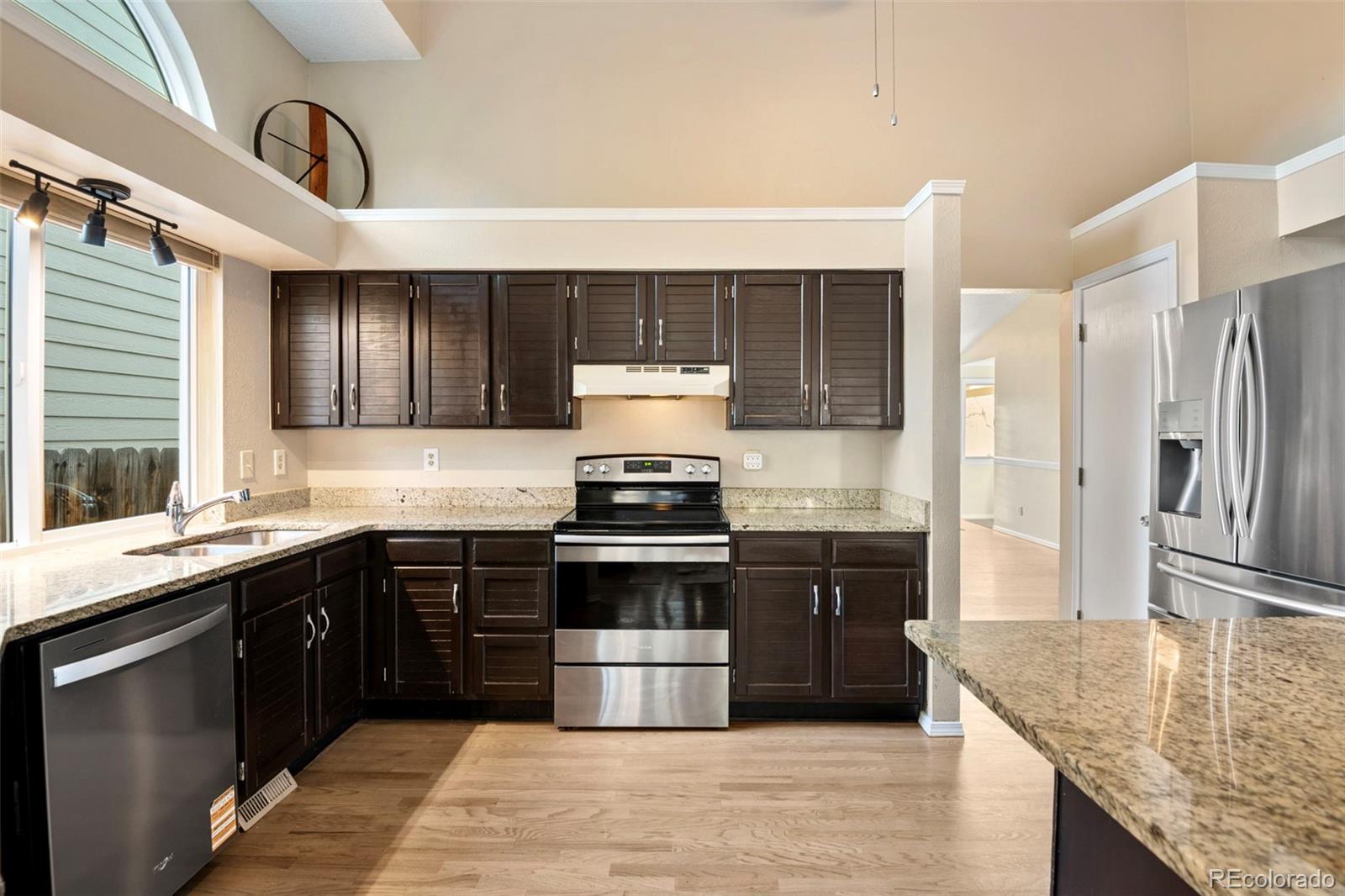 8482 Oak Street Arvada, CO 80005 - Photo 16 of 34 a kitchen with stainless steel appliances granite countertop a sink stove and refrigerator
