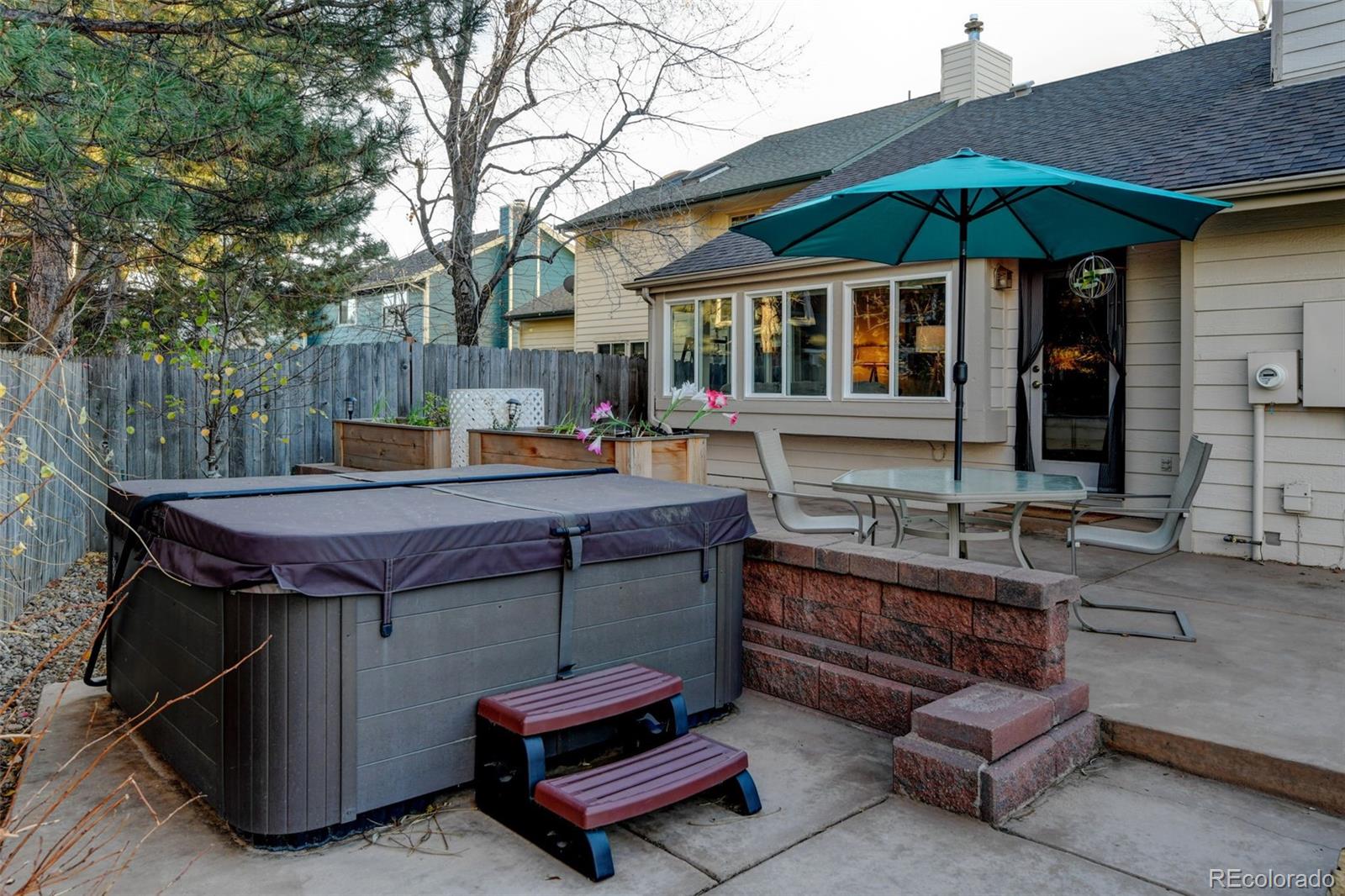 8482 Oak Street Arvada, CO 80005 - Photo 30 of 34 a patio with a table and chairs under an umbrella