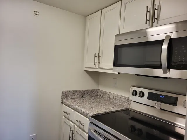 a kitchen with granite countertop cabinets stainless steel appliances and a sink