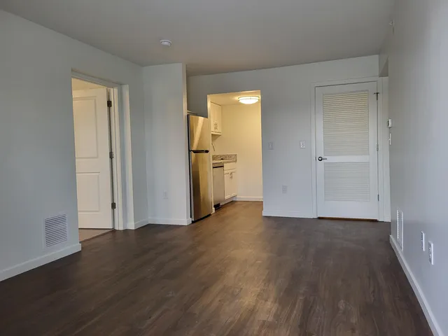 an empty room with wooden floor and closet