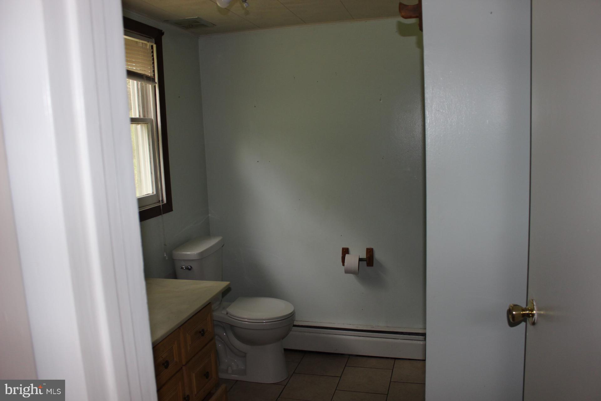 1556 Tank Road Finksburg, MD 21048 - Photo 12 of 12 a white toilet sitting next to a shower