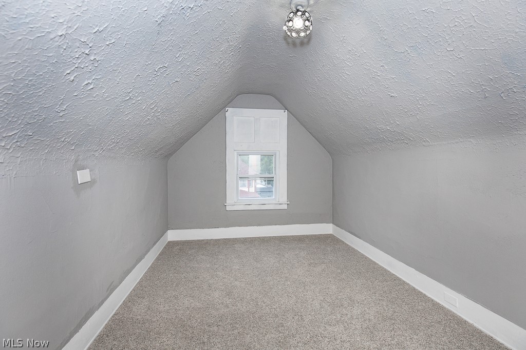 1892 Beersford Road Cleveland, OH 44112 - Photo 32 of 47 Bonus room with carpet, vaulted ceiling, and a textured ceiling
