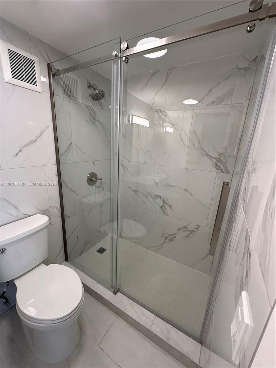 798 Crandon Boulevard, Unit 38C Key Biscayne, FL 33149 - Photo 19 of 33 a bathroom with a shower and a toilet
